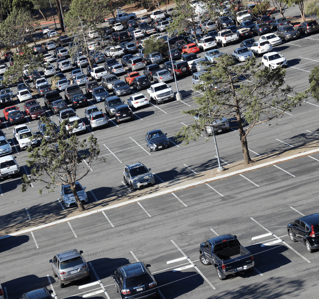 Aerial view of a full Cal Poly campus parking lot with rows of cars and scattered trees
