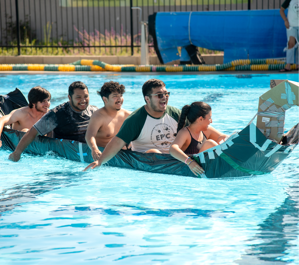 Group of students paddling a homemade cardboard boat during a pool competition at Cal Poly EPIC summer camp