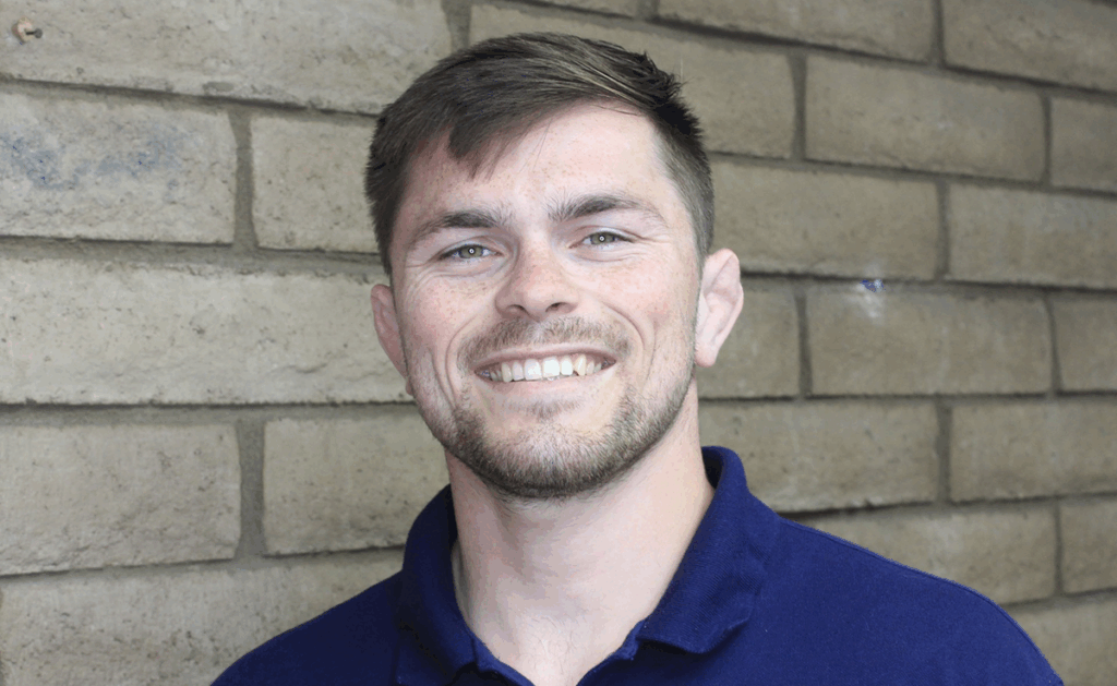 Headshot of Nathan, Cal Poly staff member, in a navy blue polo shirt
