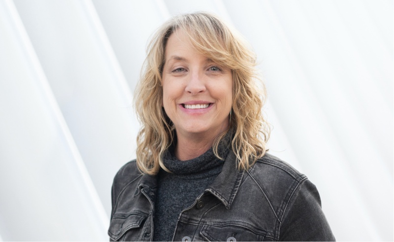 Headshot of Tammy in a denim jacket with a light background